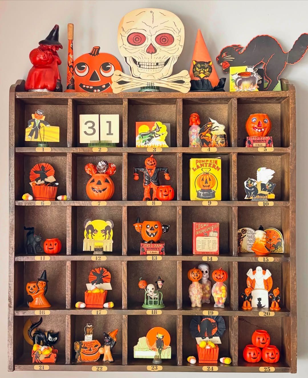 Vintage Halloween advent calendar with various nostalgic figurines and a large skull on top.