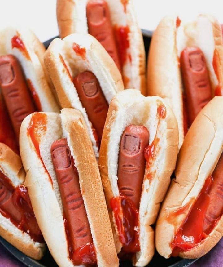 Finger shaped hot dogs in buns with red ketchup as blood for Halloween.