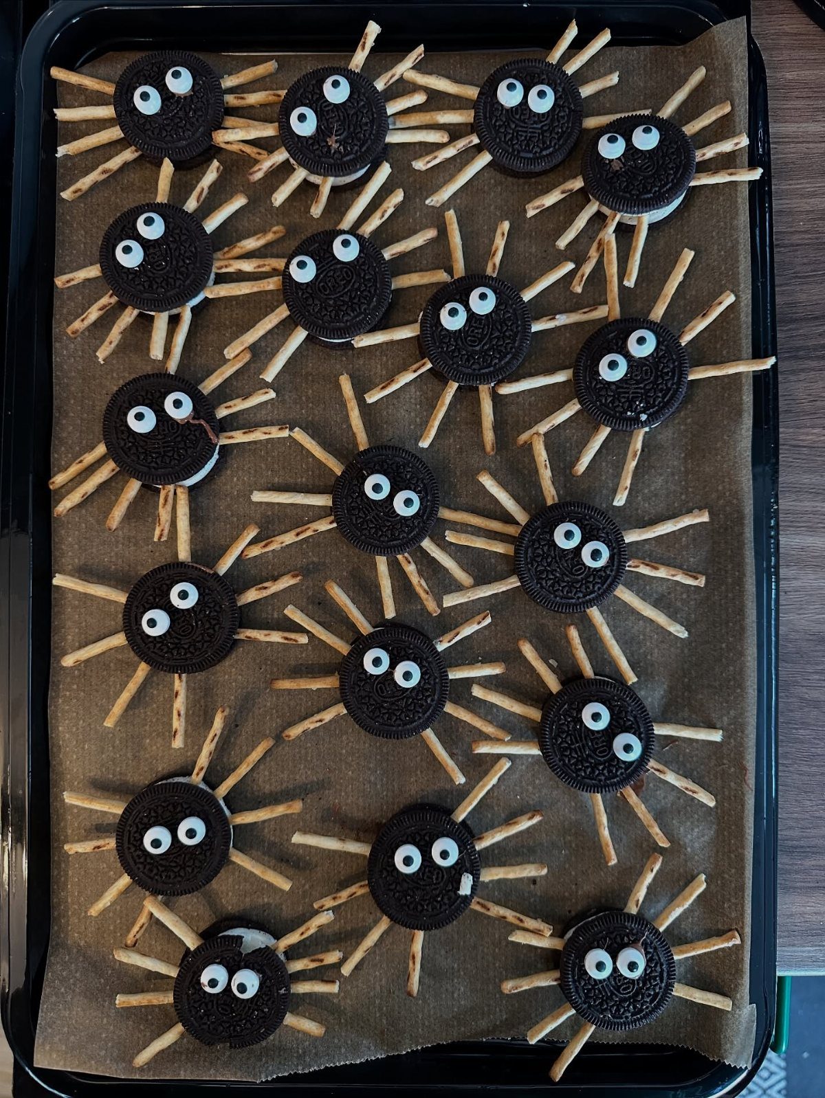 Spider-shaped treats made from chocolate sandwich cookies, pretzel sticks, and candy eyes.
