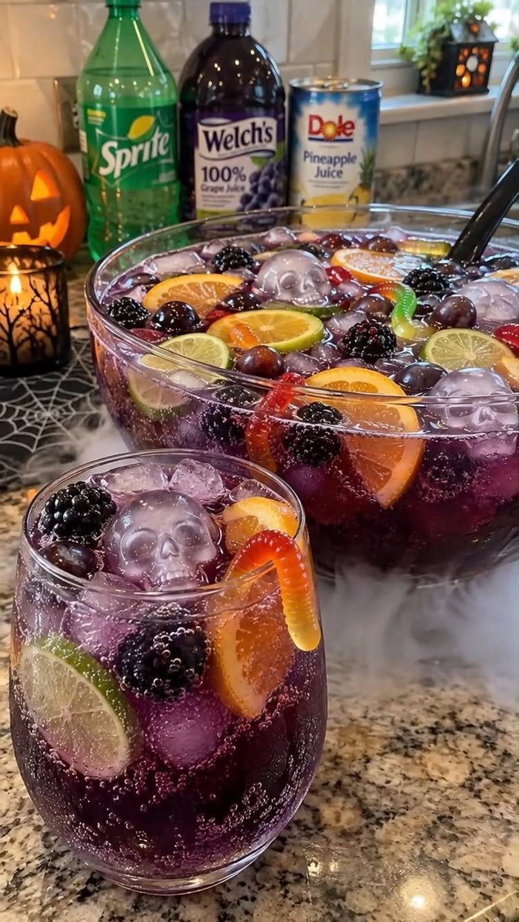 Purple sparkling punch with skull ice cubes, citrus slices, and berries in glassware.