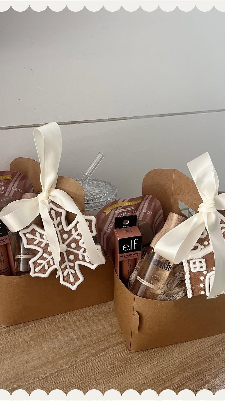 Brown cardboard gift boxes with white ribbons containing cookies and beauty products.