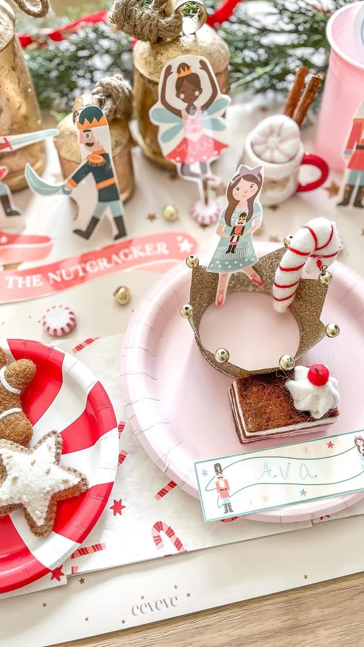 Festive holiday table setting with Nutcracker decorations, gingerbread cookies, and pink plates.