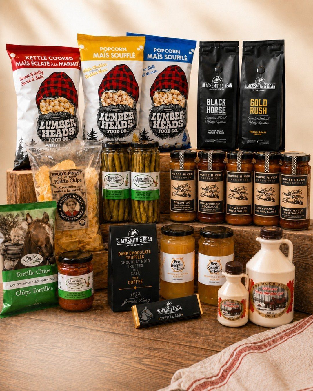 Gourmet food gift basket with popcorn, coffee, and preserves on wooden crates.