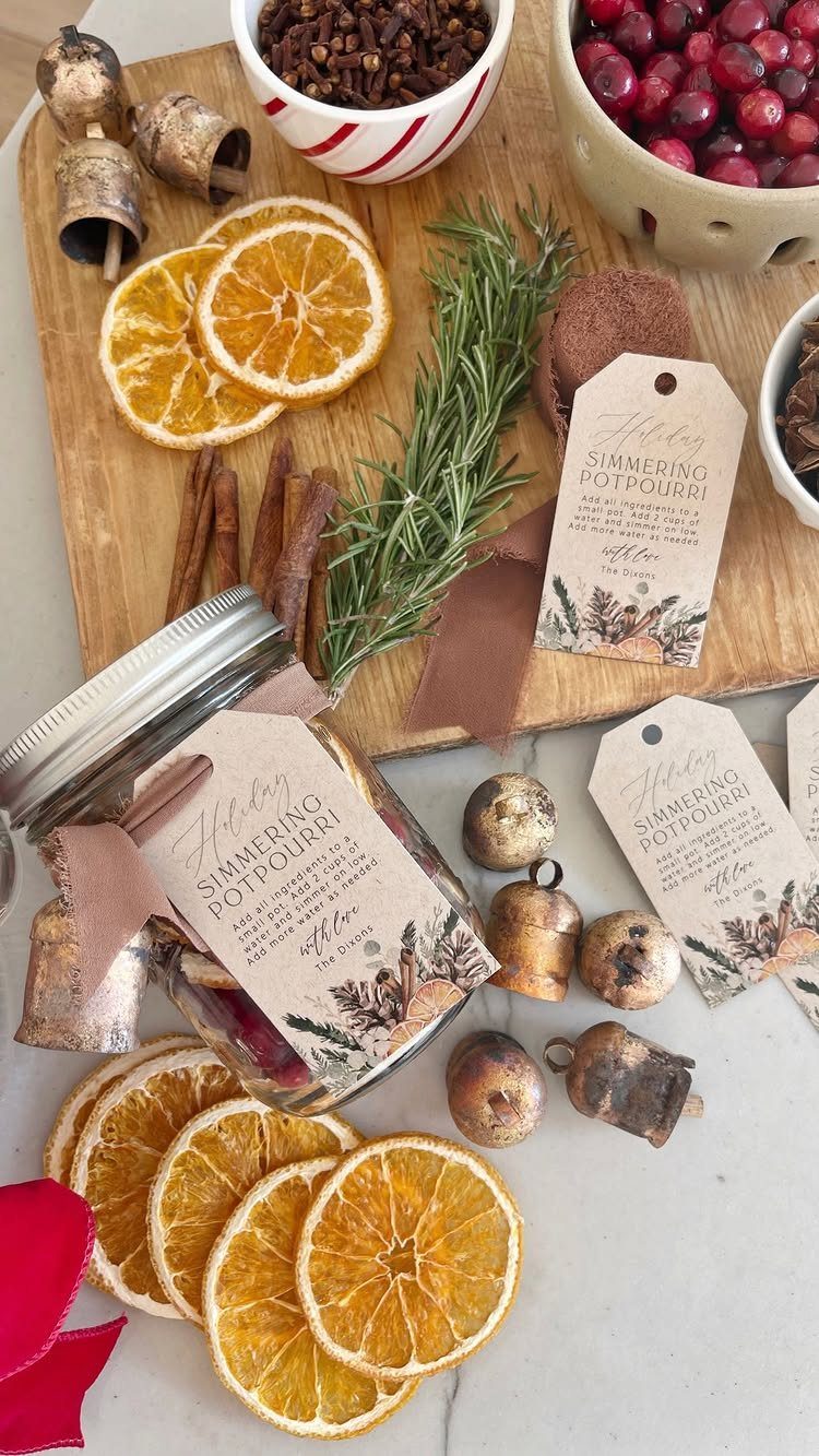Simmering potpourri jar with dried oranges, cinnamon, and cranberries on a wooden board.