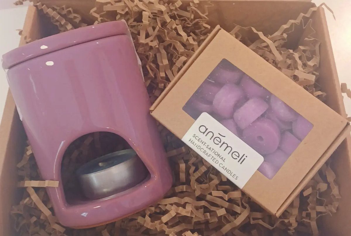 Purple ceramic wax melter and matching wax melts in a gift box.
