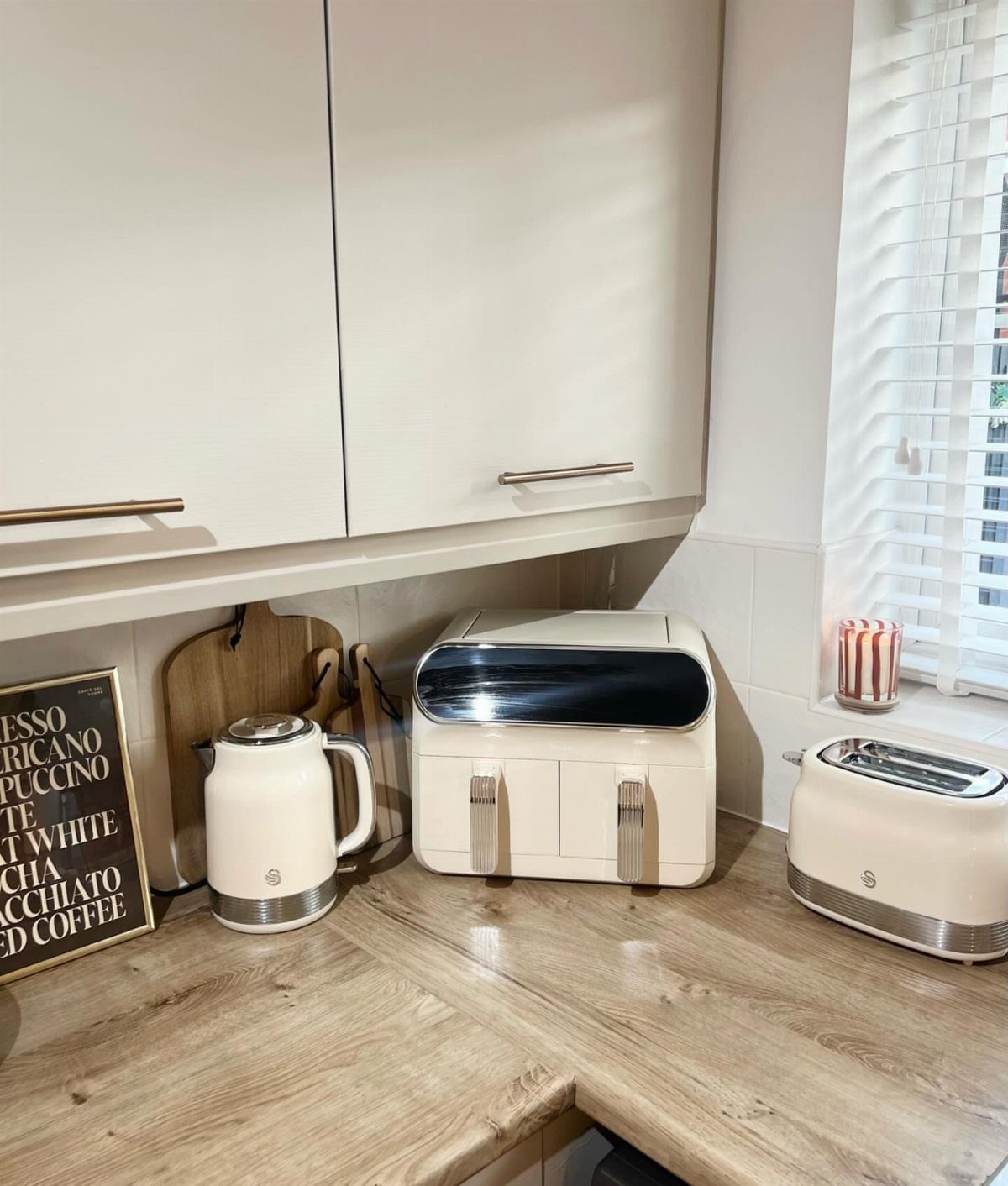 Cream electric kettle and matching kitchen appliances on a light wood countertop.