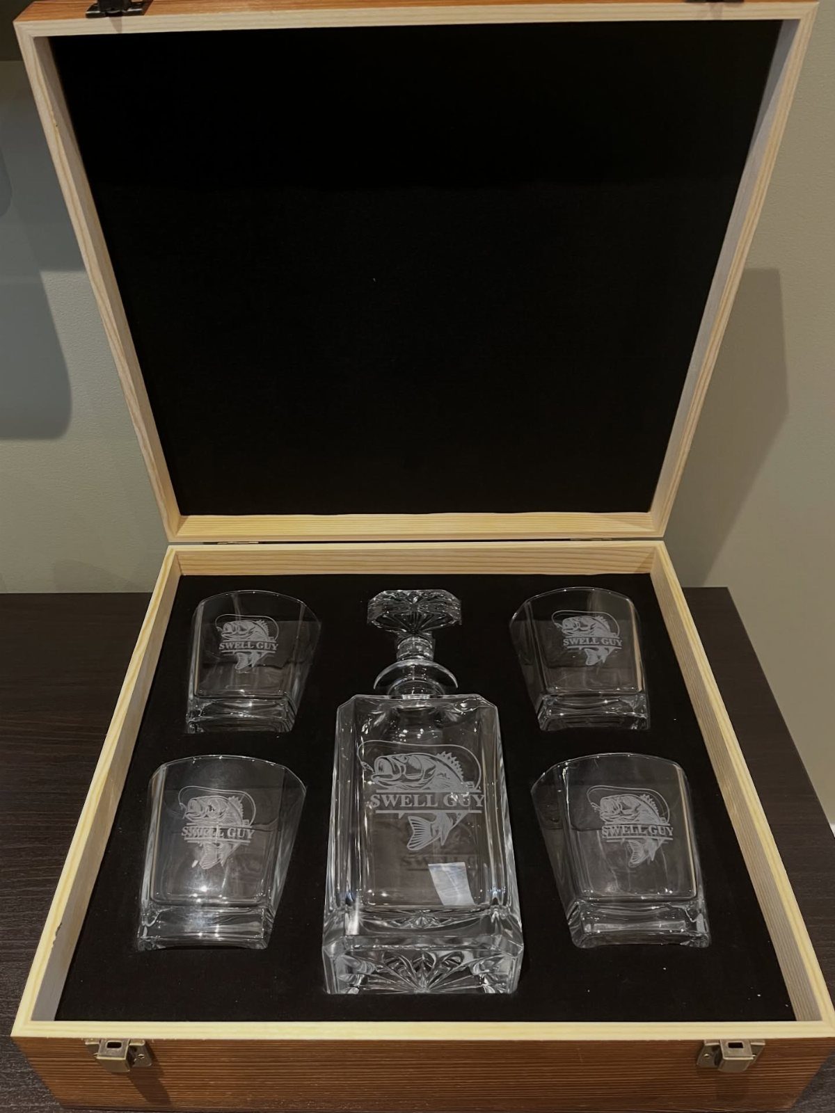 Glass decanter and four matching glasses in a wooden gift box with foam.