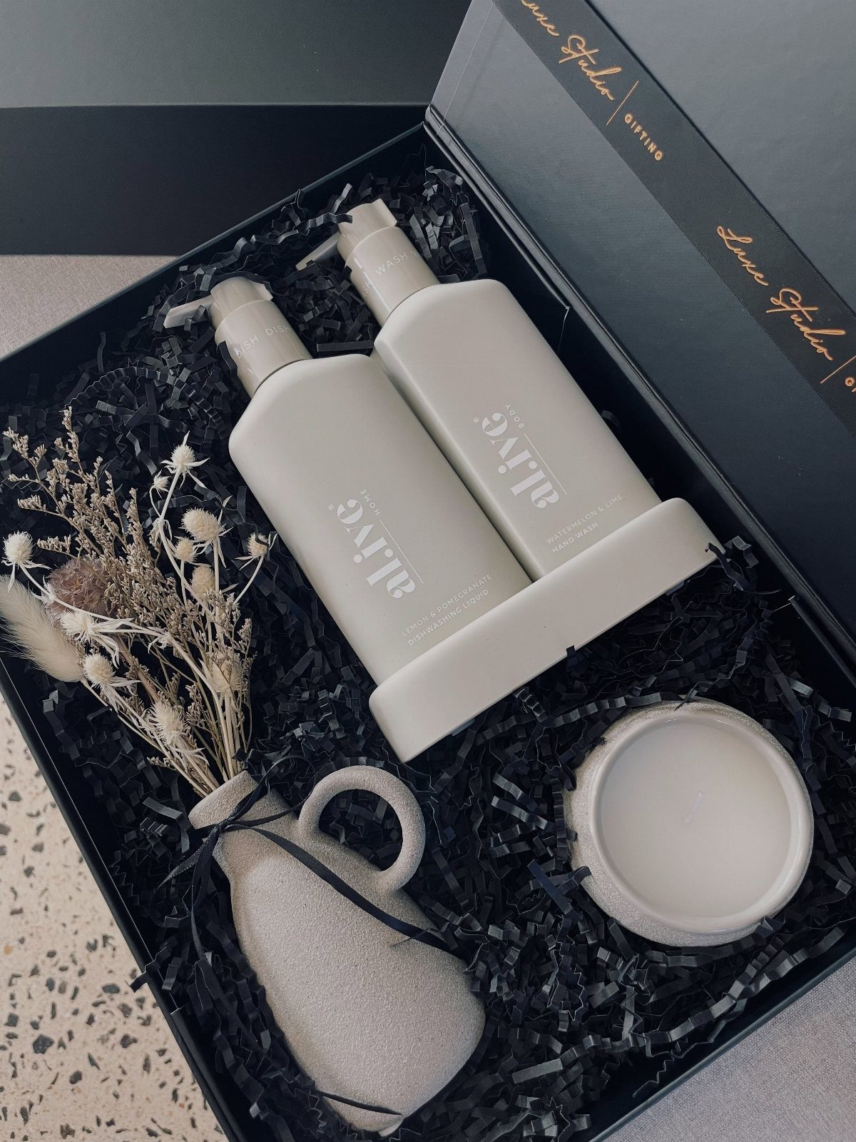 Luxury handcare set with pump bottles and dried flowers in a black gift box