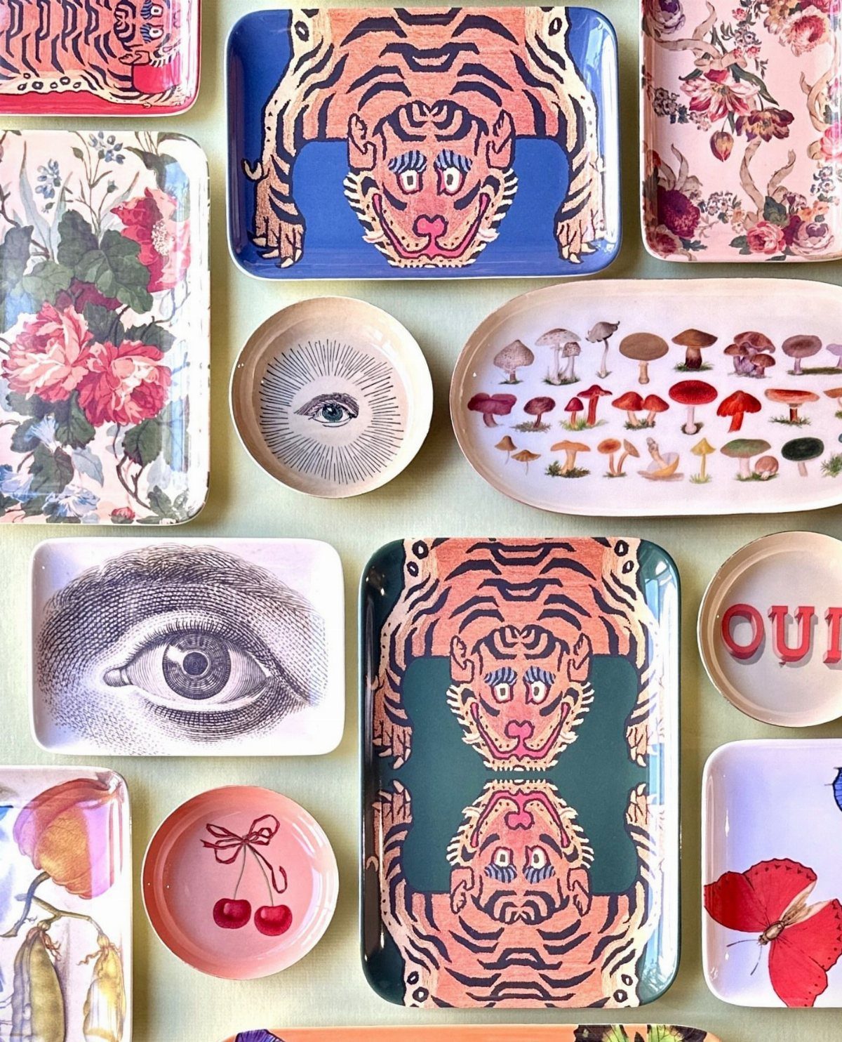 Assorted ceramic trinket dishes with colorful illustrations of tigers, eyes, and mushrooms.