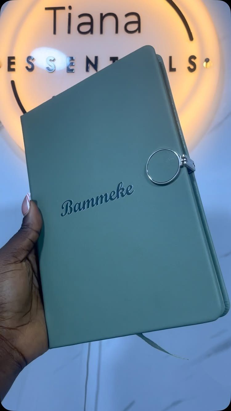 Sage green personalized notebook with embossed name held by a hand.