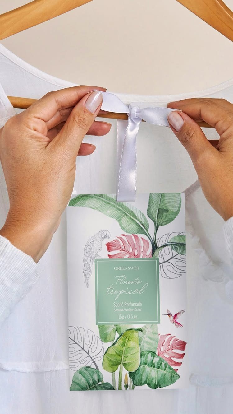 Tropical leaf printed scented sachet hanging from a wooden hanger with white ribbon
