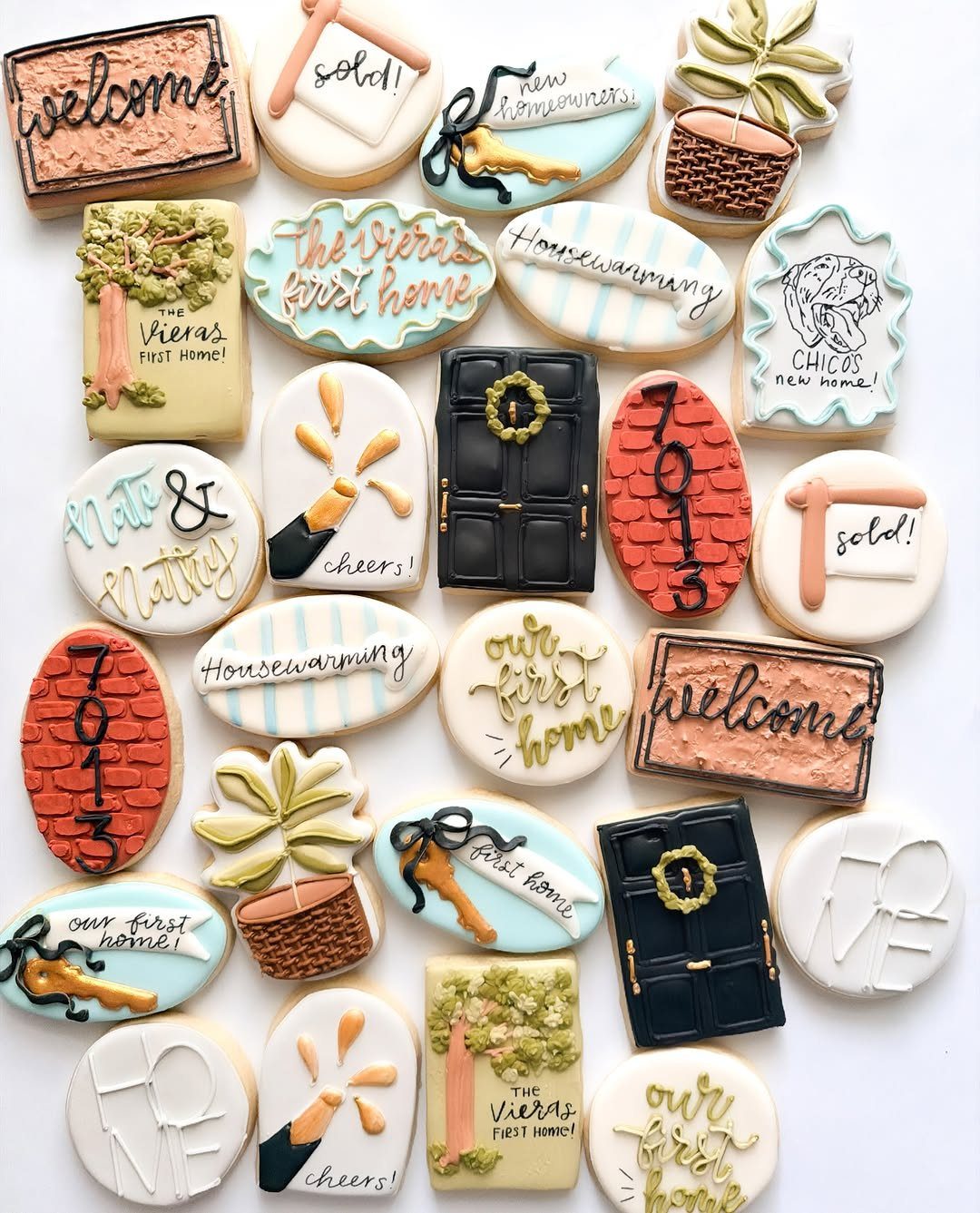 Decorated sugar cookies with housewarming themes, including keys, doors, and welcome mats.