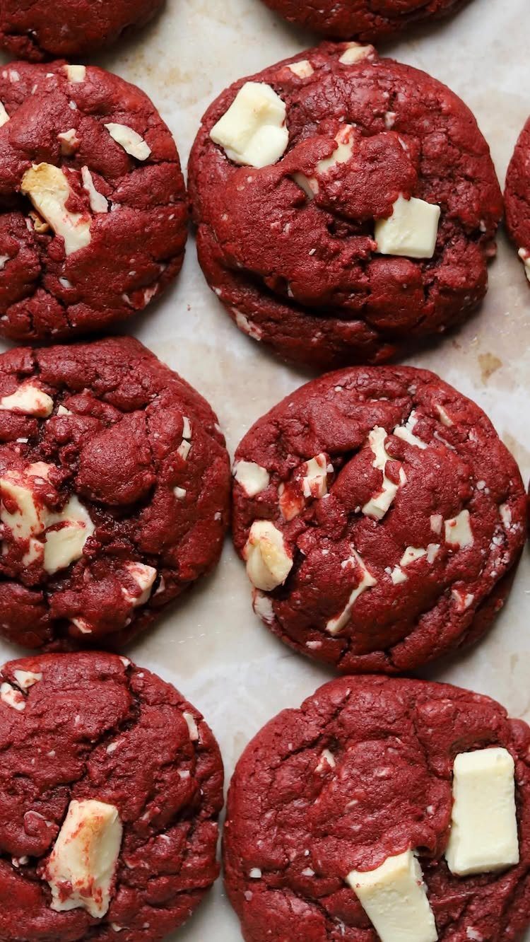 Red velvet chocolate chip cookies with white chunks on a baking sheet.