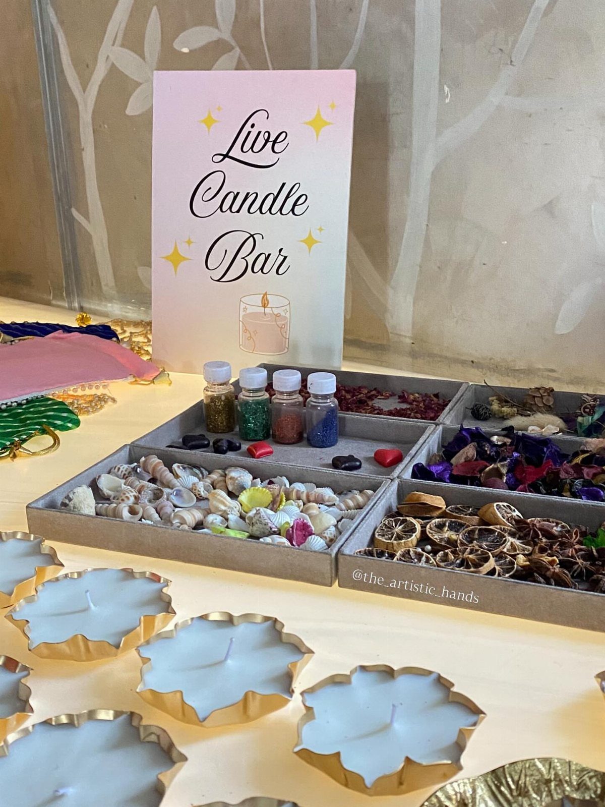 Live candle bar setup with decorative shells, dried fruit, and gold leaf candles.