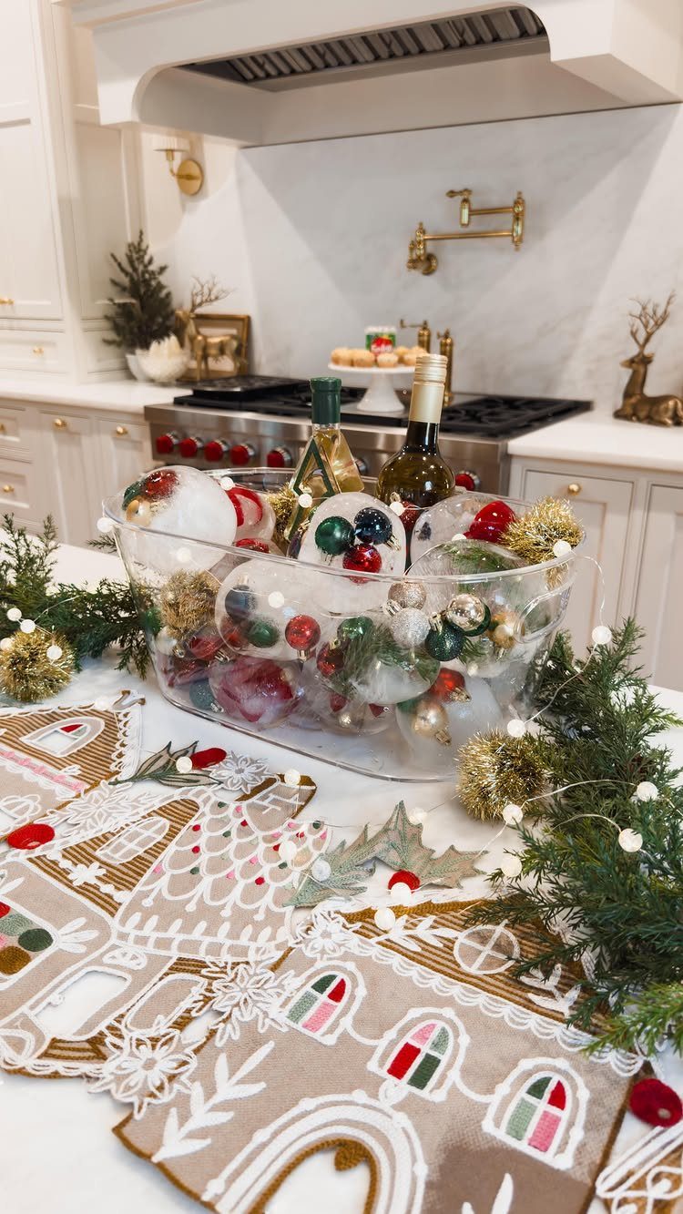 Christmas party decorations with ornament-filled bowl and gingerbread placemats on a white counter.