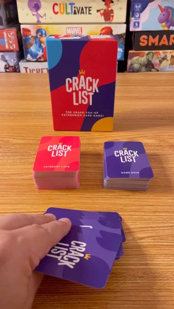Crack List card game box and cards arranged on a wooden table surface