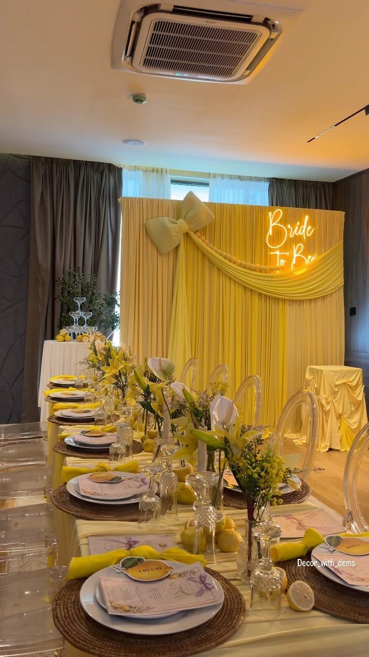 Bridal shower table setting with yellow decor and Bride To Be neon sign