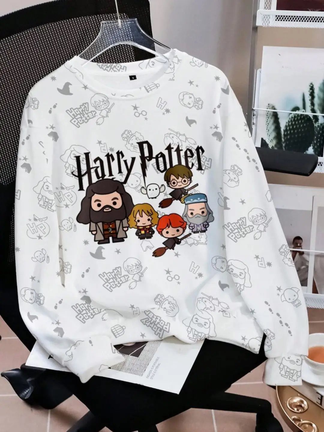 White Harry Potter crewneck sweatshirt with chibi character graphics and themed patterns.