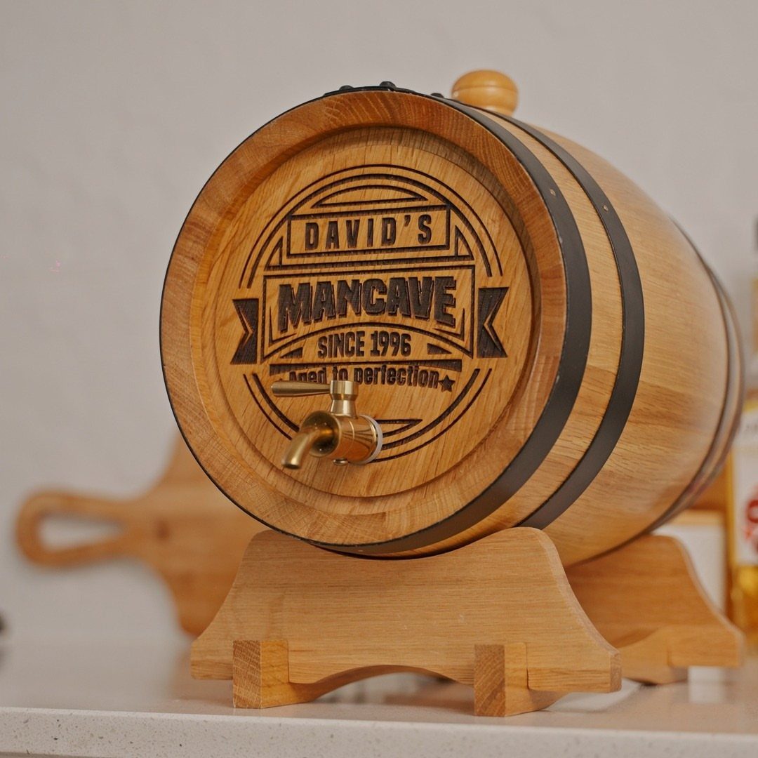 Small wooden whiskey barrel engraved with David's Mancave on a wooden stand