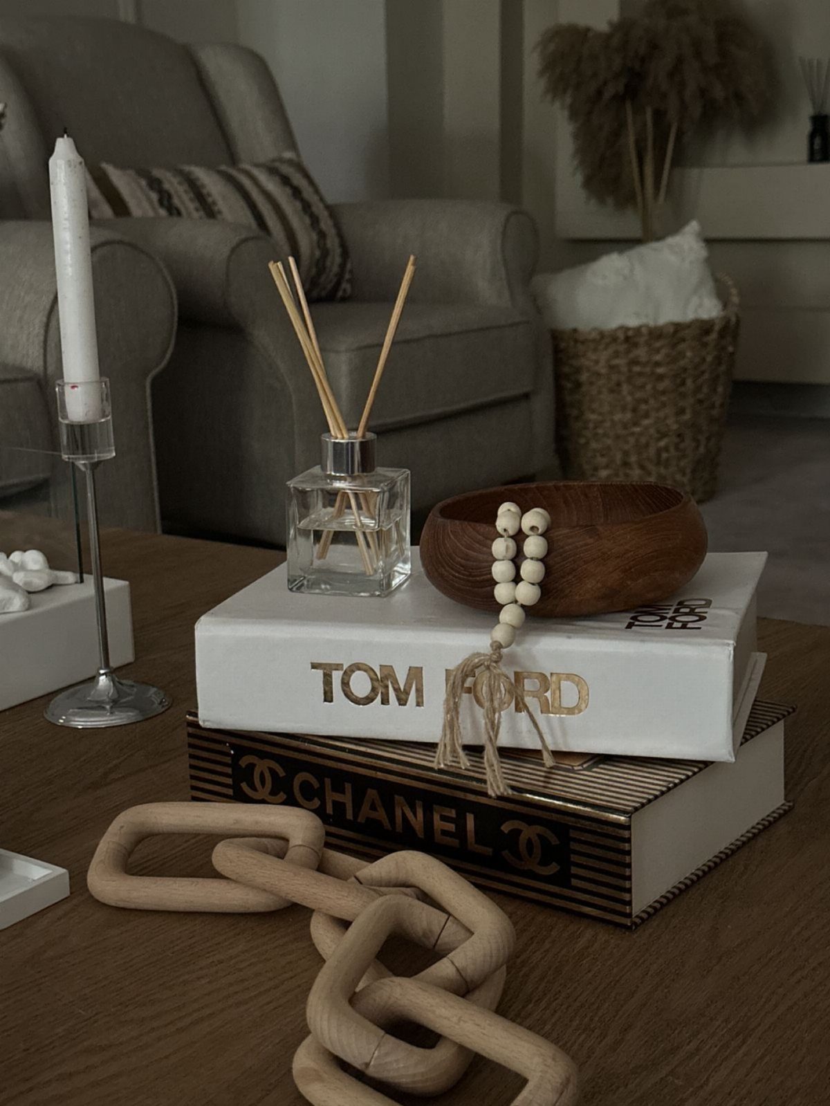 Stacked Tom Ford and Chanel coffee table books with decorative home accessories.