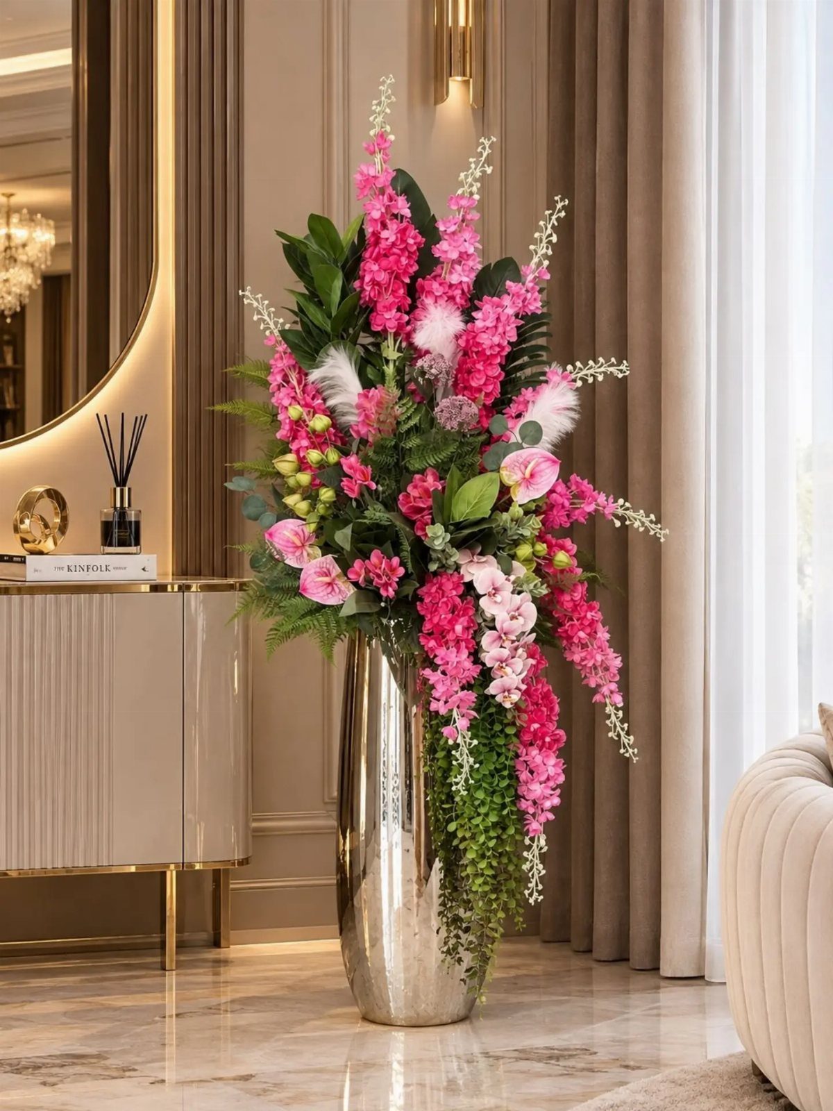Tall silver metallic vase with a large arrangement of pink flowers in a luxury room.
