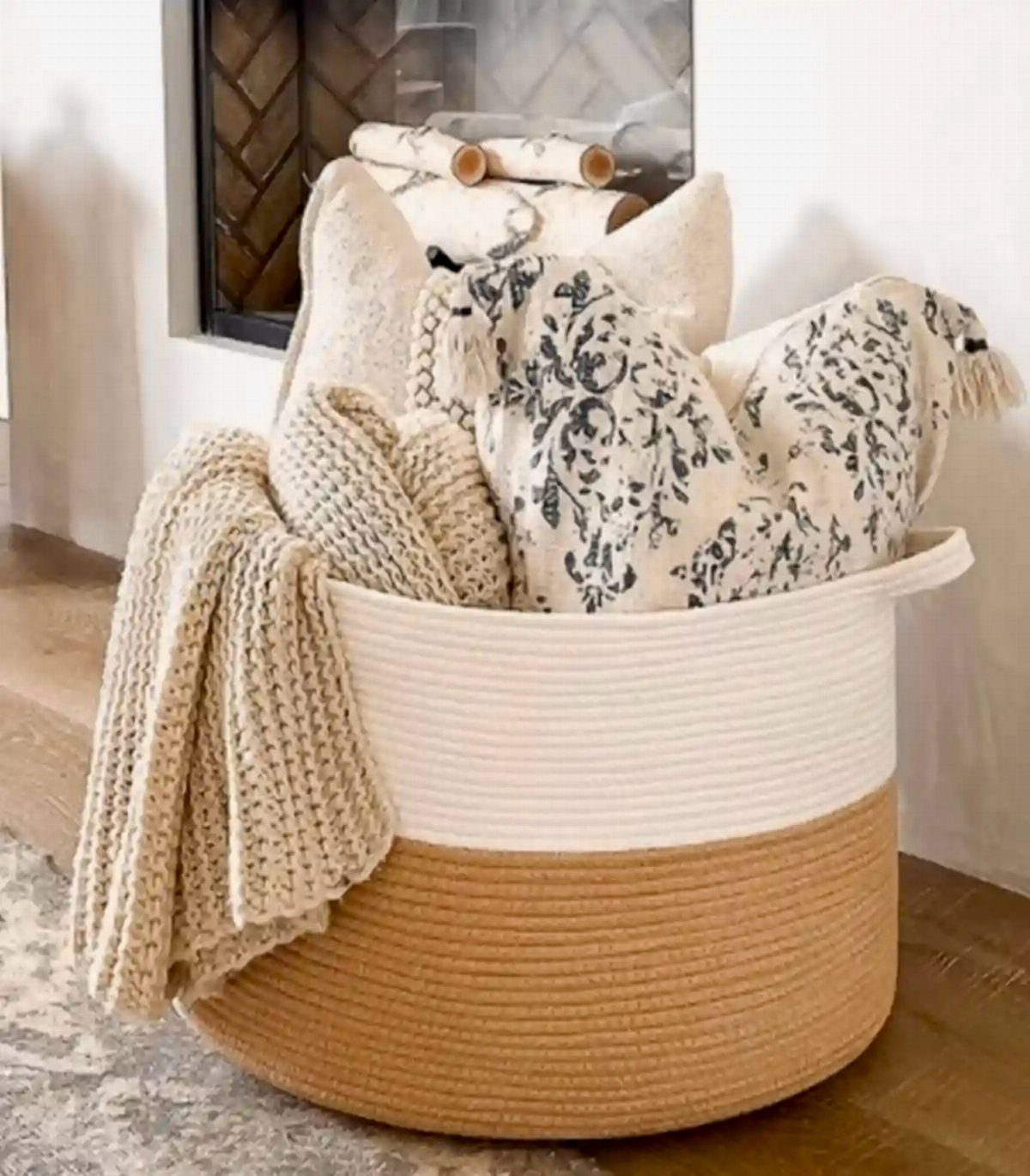 Woven basket filled with cozy knit blankets and floral patterned throw pillows.