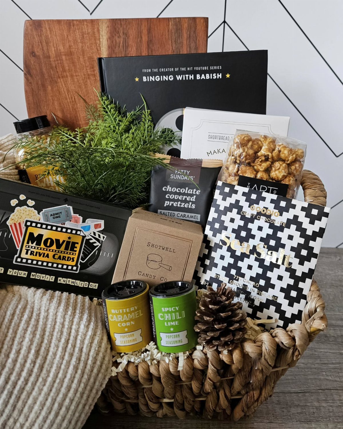 Woven gift basket filled with movie trivia cards, popcorn, and themed snacks.