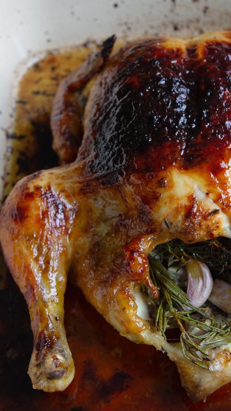 Roasted Cornish game hen stuffed with rosemary and garlic in a white dish