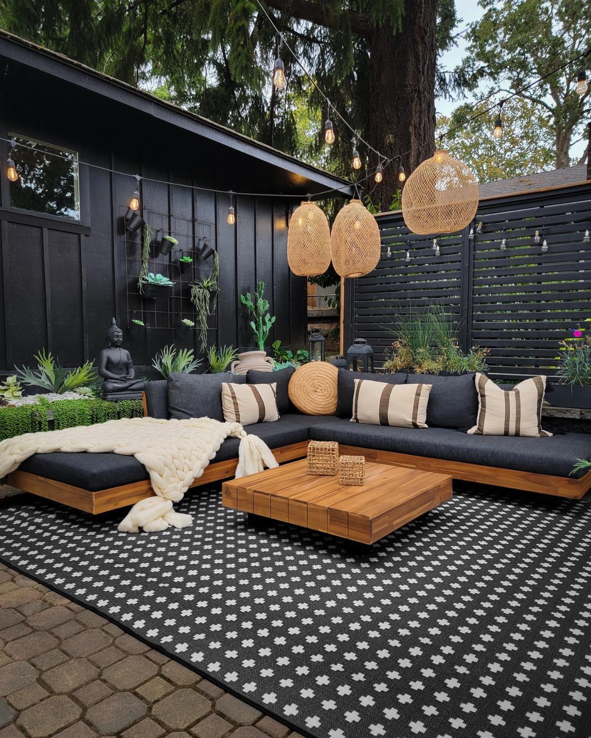 Black and white patterned outdoor rug under a modern lounge seating area.