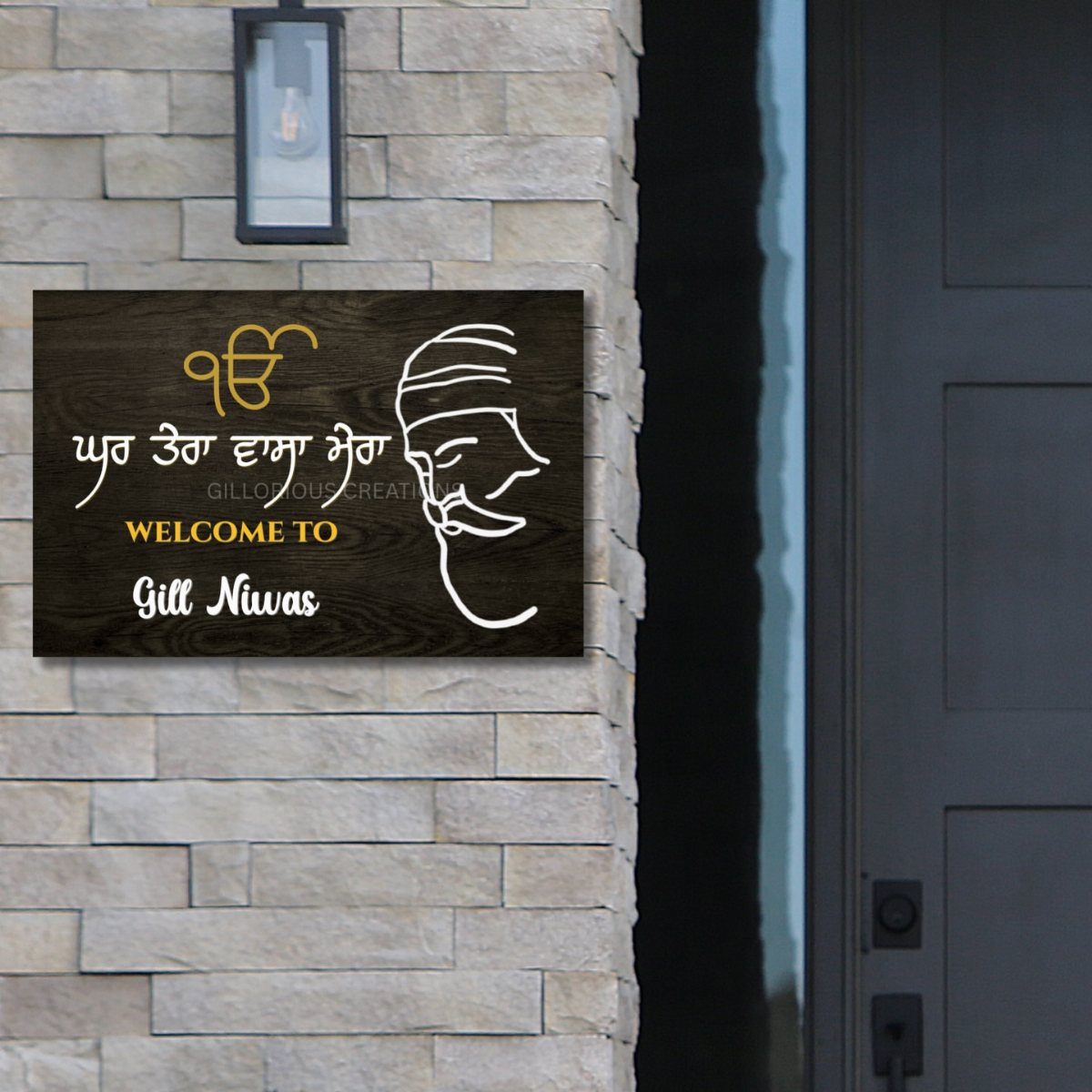 Personalized wooden home sign with Punjabi text and a man's profile on stone wall