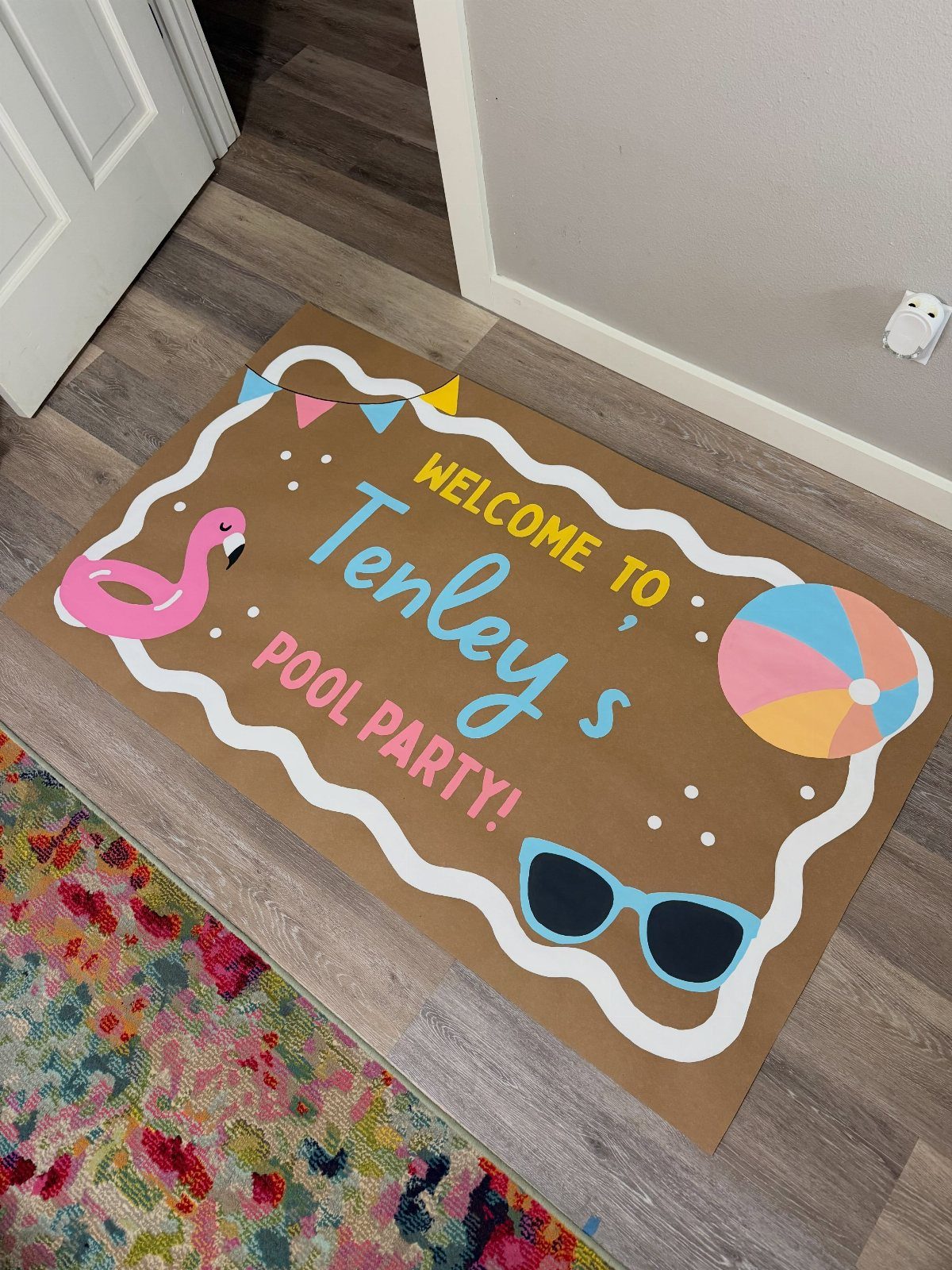 Welcome mat for a pool party with flamingo and beach ball illustrations.