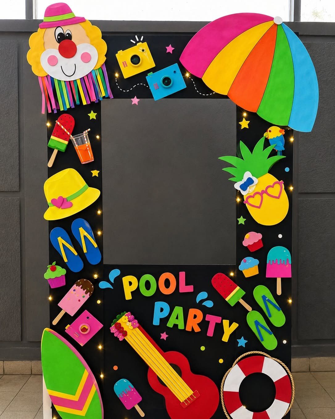 Pool party photo booth frame decorated with colorful beach-themed cutouts and bright lettering.