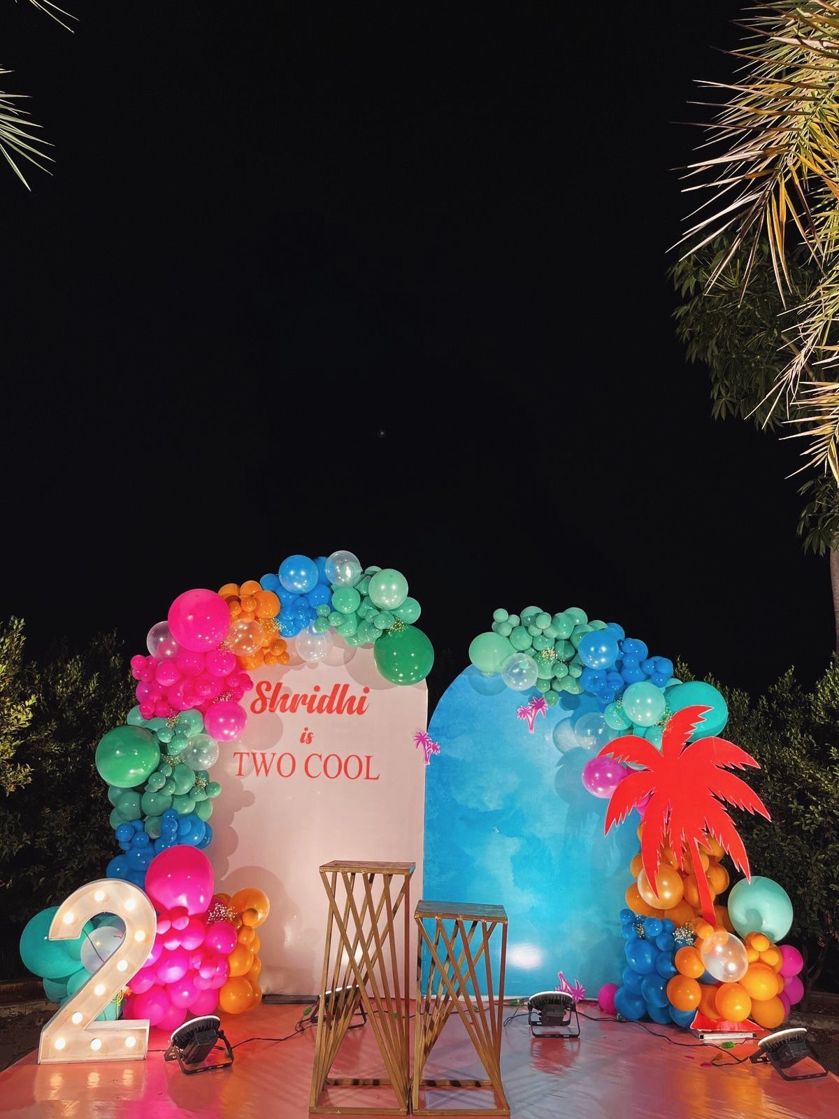Colorful balloon arch and 'Two Cool' backdrop for a child's pool party theme.