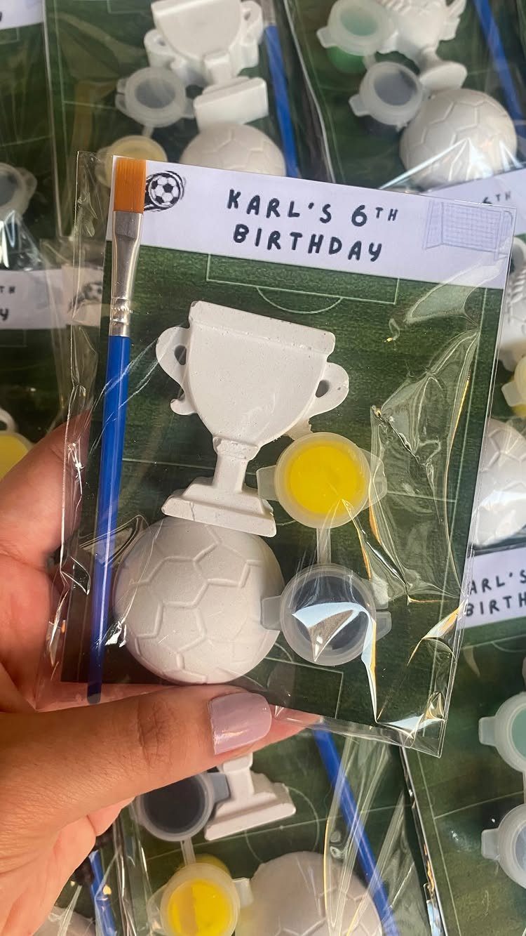 Wooden soccer ball and trophy painting kit in a clear plastic party bag.