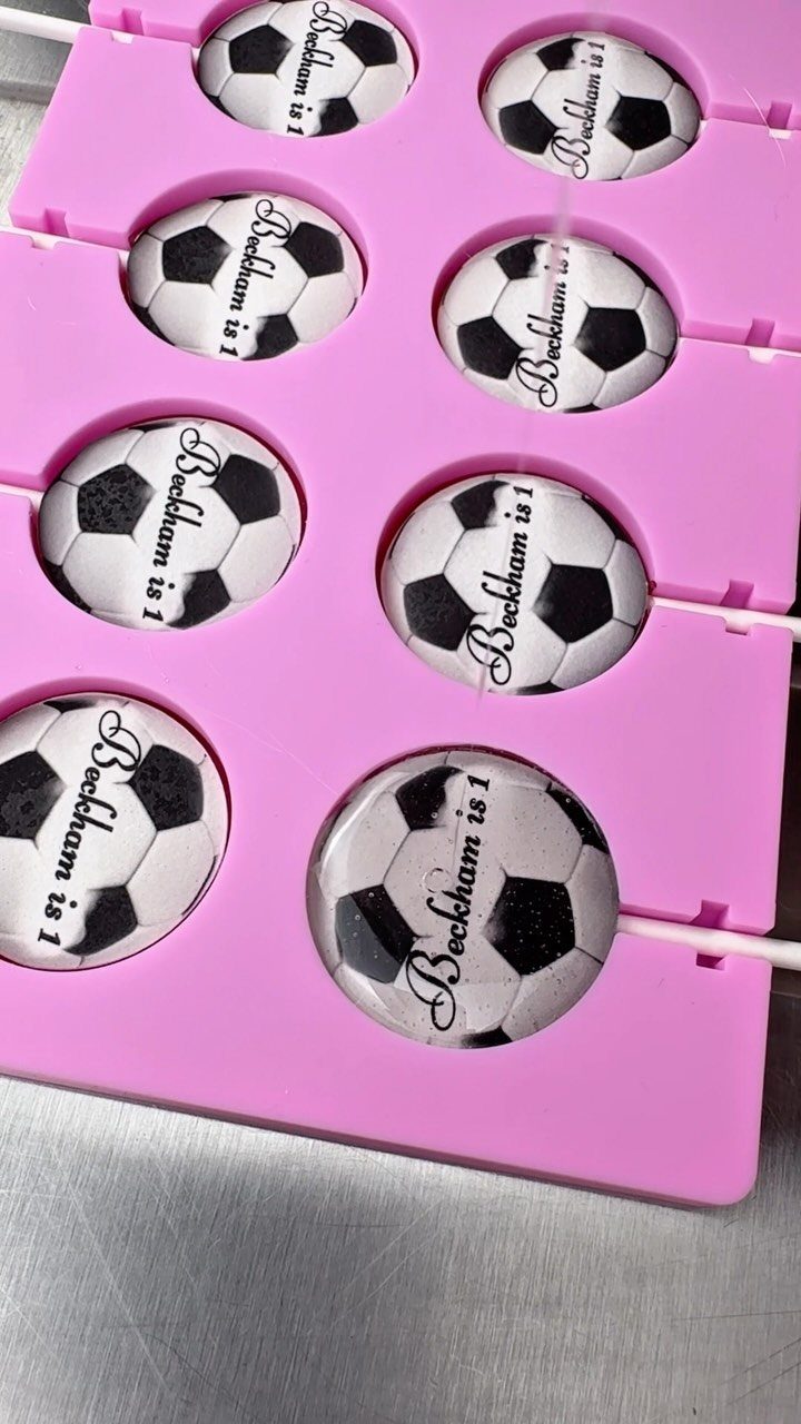 Soccer ball cake pops in a pink mold with Beckham is 1 text.