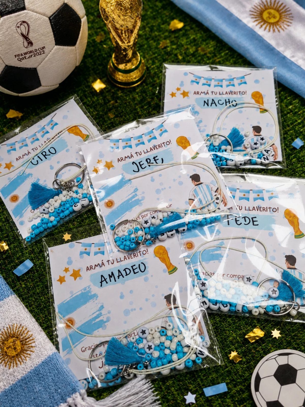 Personalized soccer keychain making kits in plastic bags on green artificial grass.