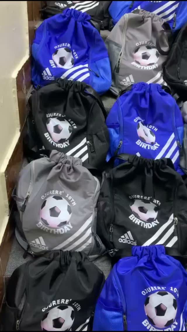 Drawstring backpacks in blue, black, and grey with soccer ball birthday graphics.