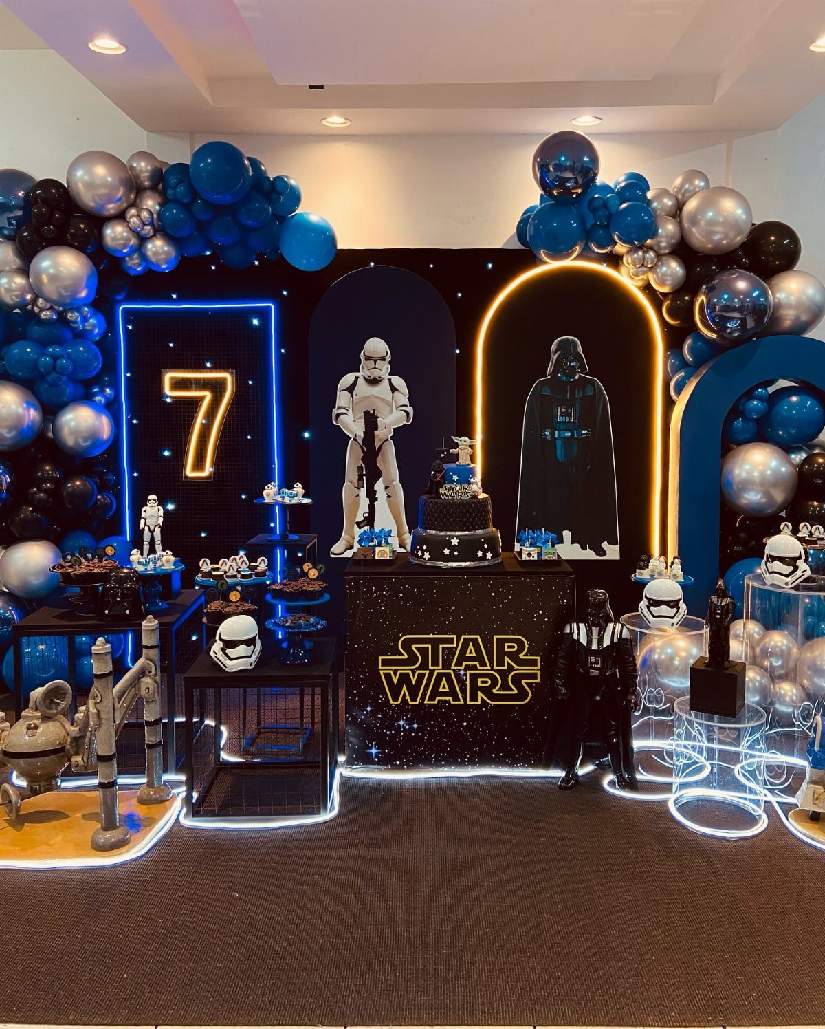 Star Wars party decorations featuring blue and silver balloons and character figures.