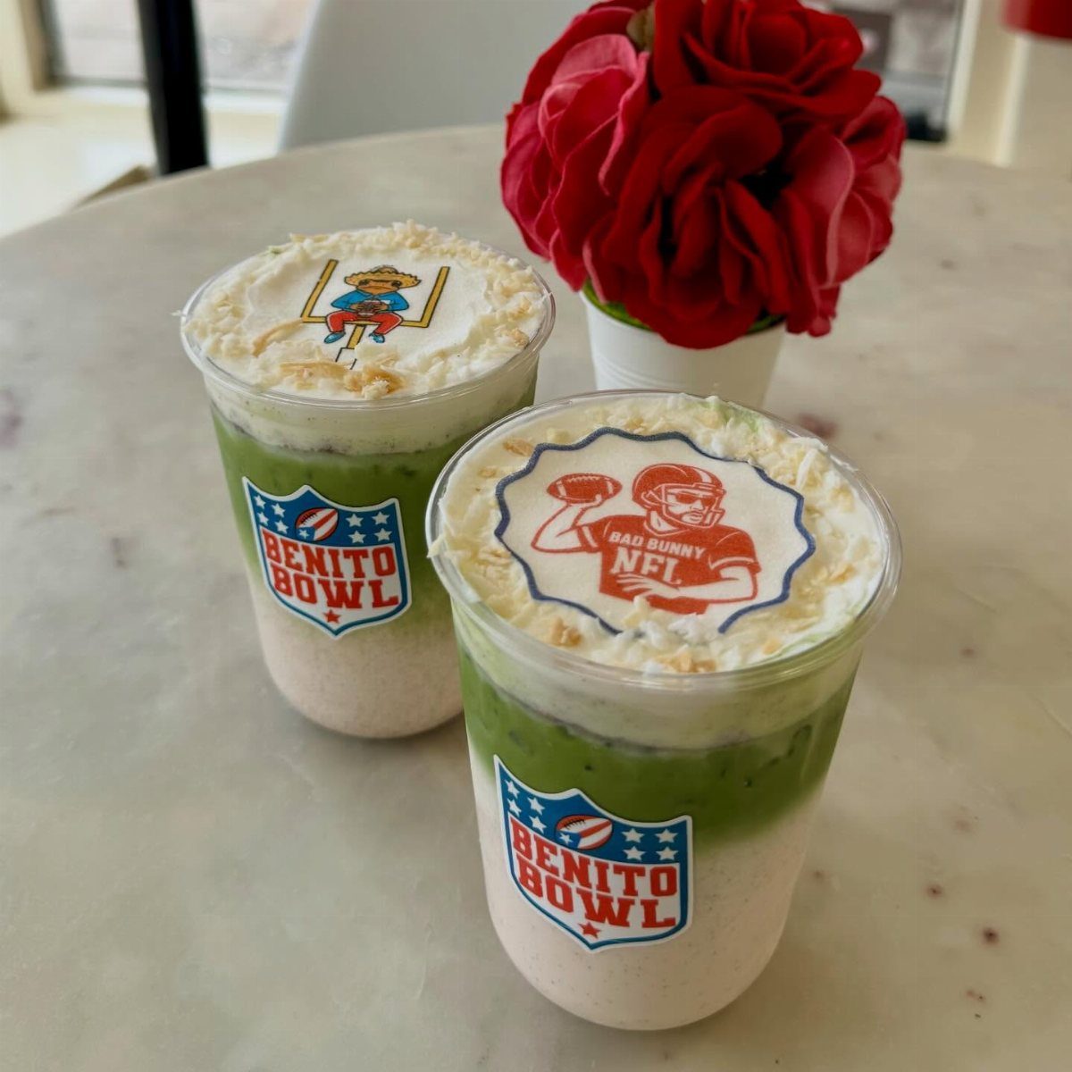 Two layered green and white drinks with football-themed toppers and red roses.