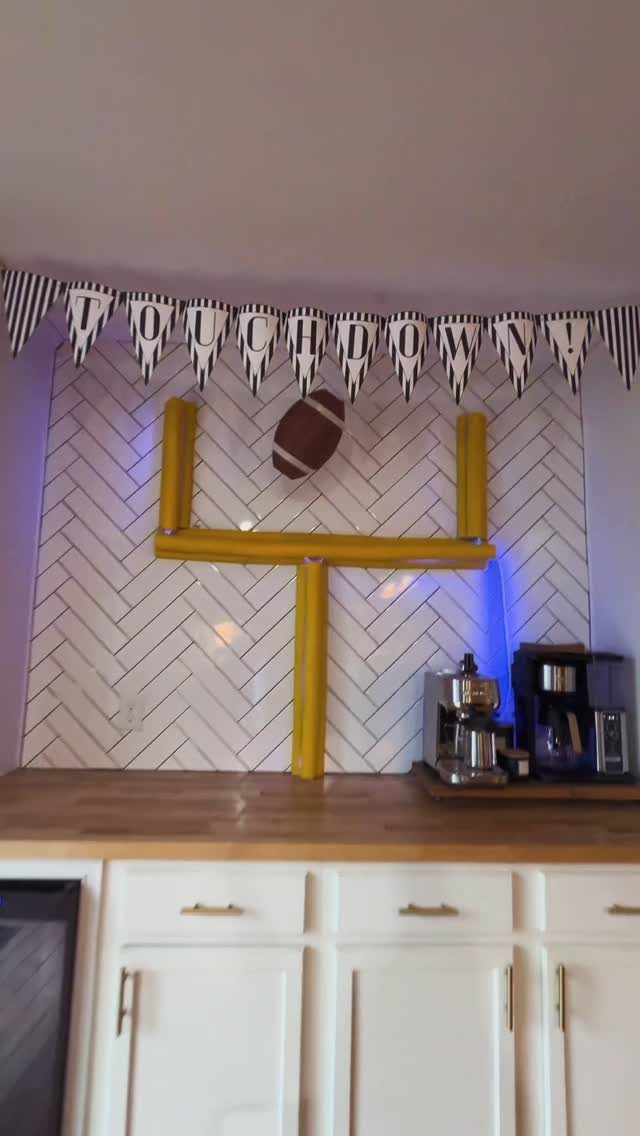 Yellow goal post and touchdown banner decoration on a white tiled kitchen counter.