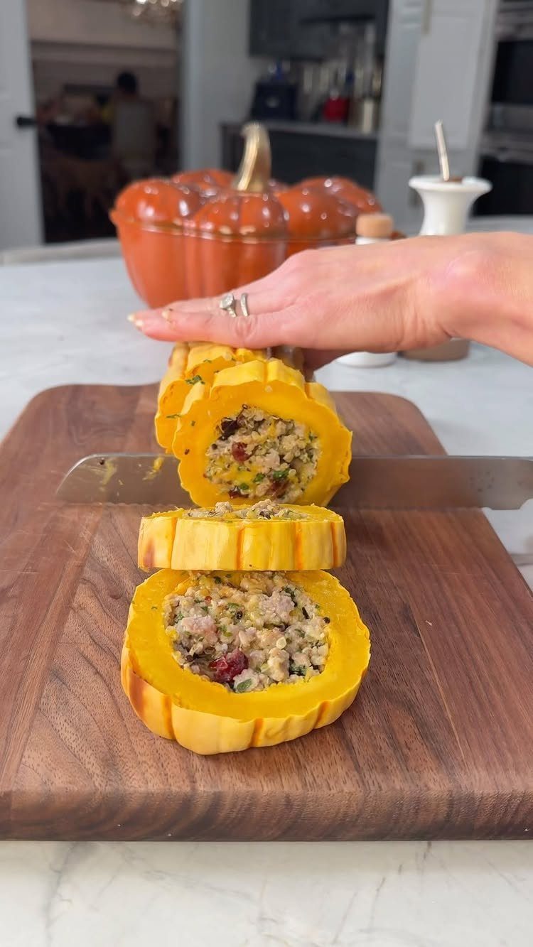 Stuffed yellow squash slices with savory filling on a wooden cutting board.