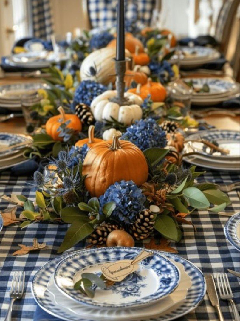 Layered blue and white patterned plates on a checkered tablecloth with pumpkin centerpiece.