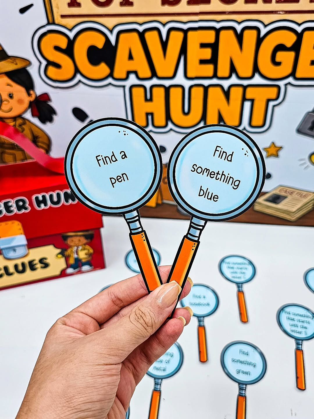 Hand holding magnifying glass paper cutouts for a scavenger hunt activity