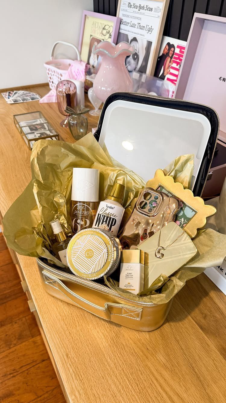 Gold beauty gift basket with skincare products, a phone case, and jewelry.