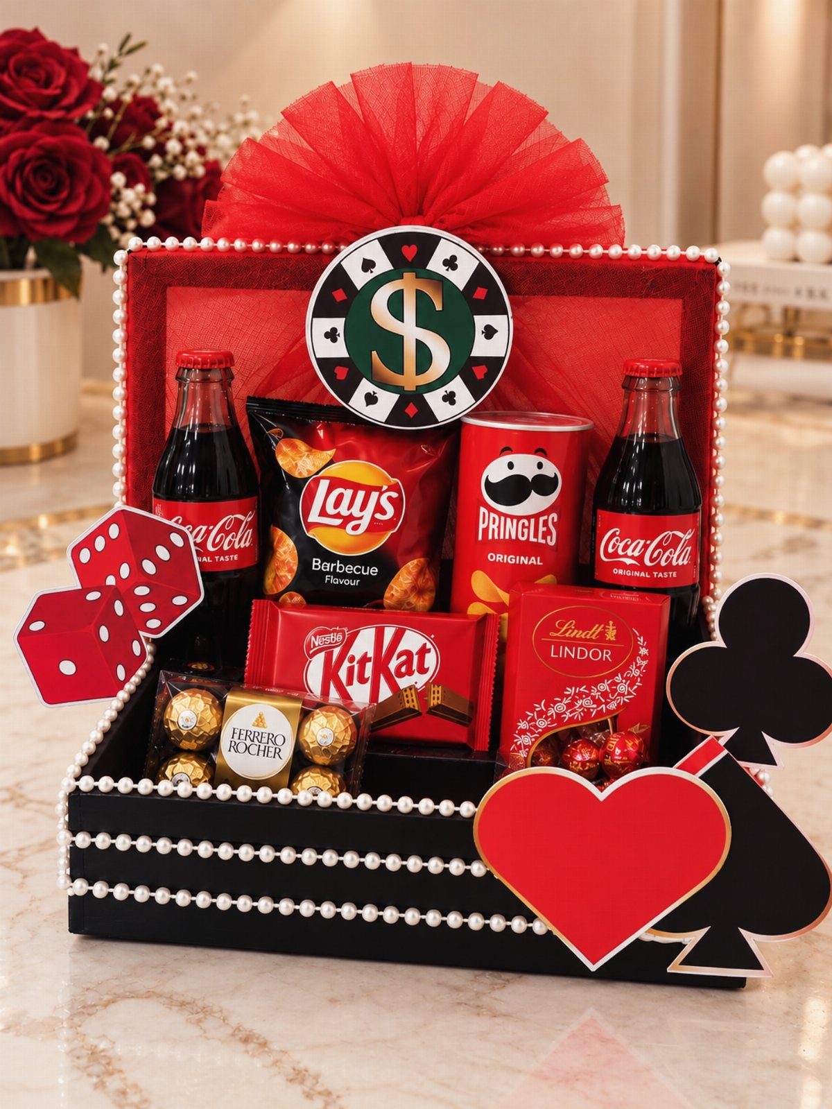 Casino themed gift basket with snacks, chocolates, and soda in a decorated box.