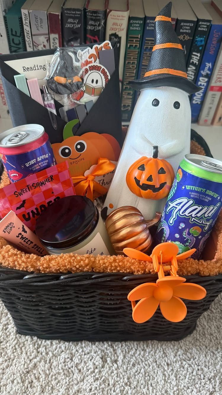Halloween themed gift basket with a ghost, pumpkins, and drinks in front of books
