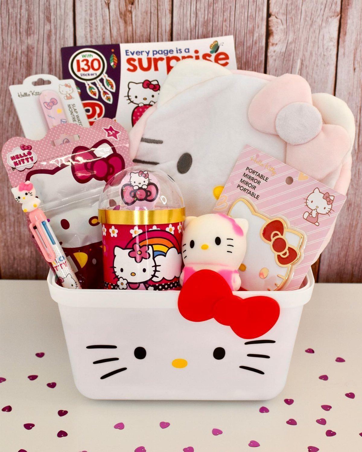 Hello Kitty themed gift basket filled with plushies, stationery, and accessories in a white bin.