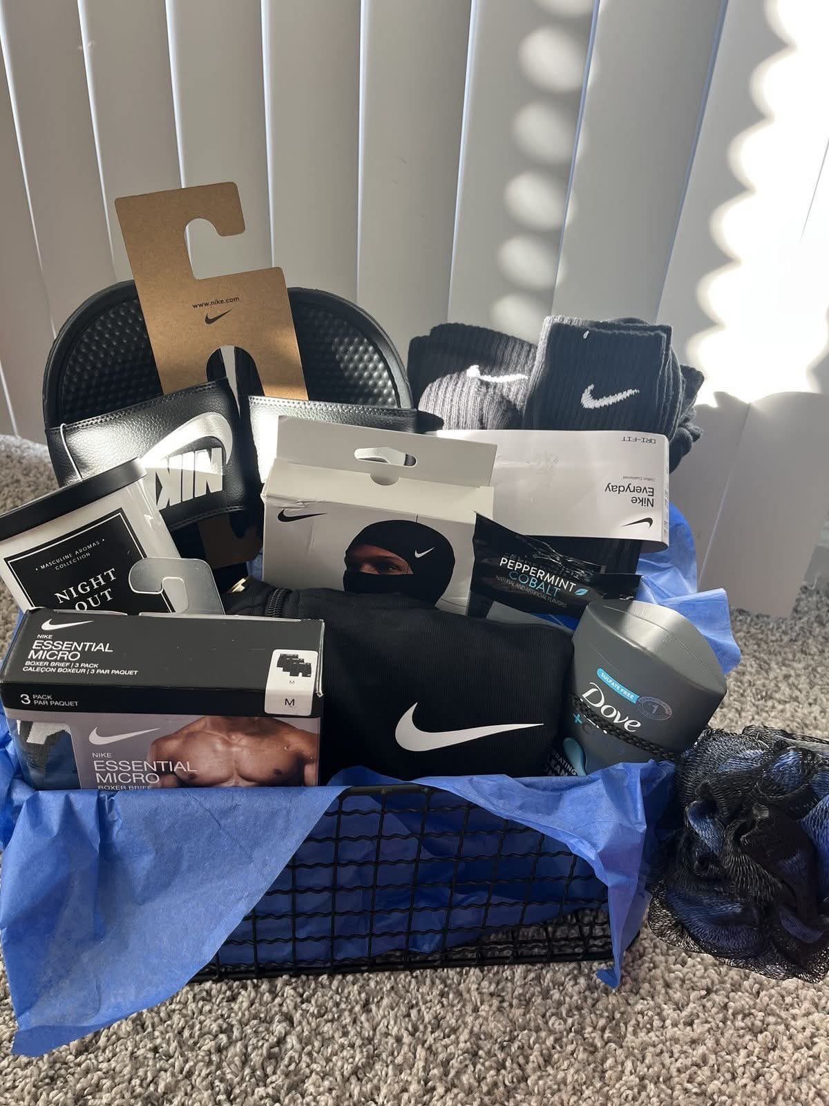 Nike branded clothing and grooming products arranged in a black wire gift basket.