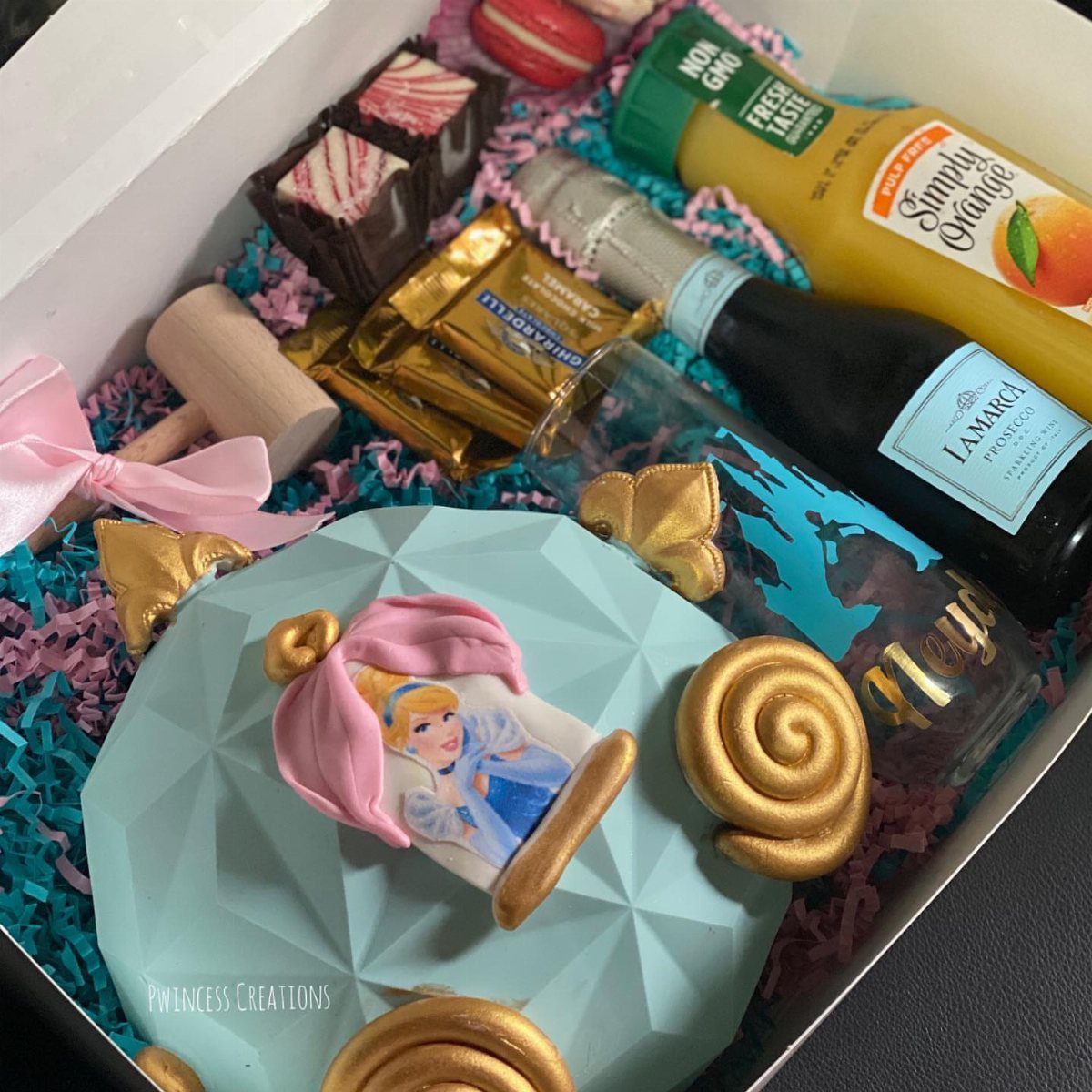 Mimosa gift basket with prosecco, orange juice, chocolates, and a Cinderella themed cake.