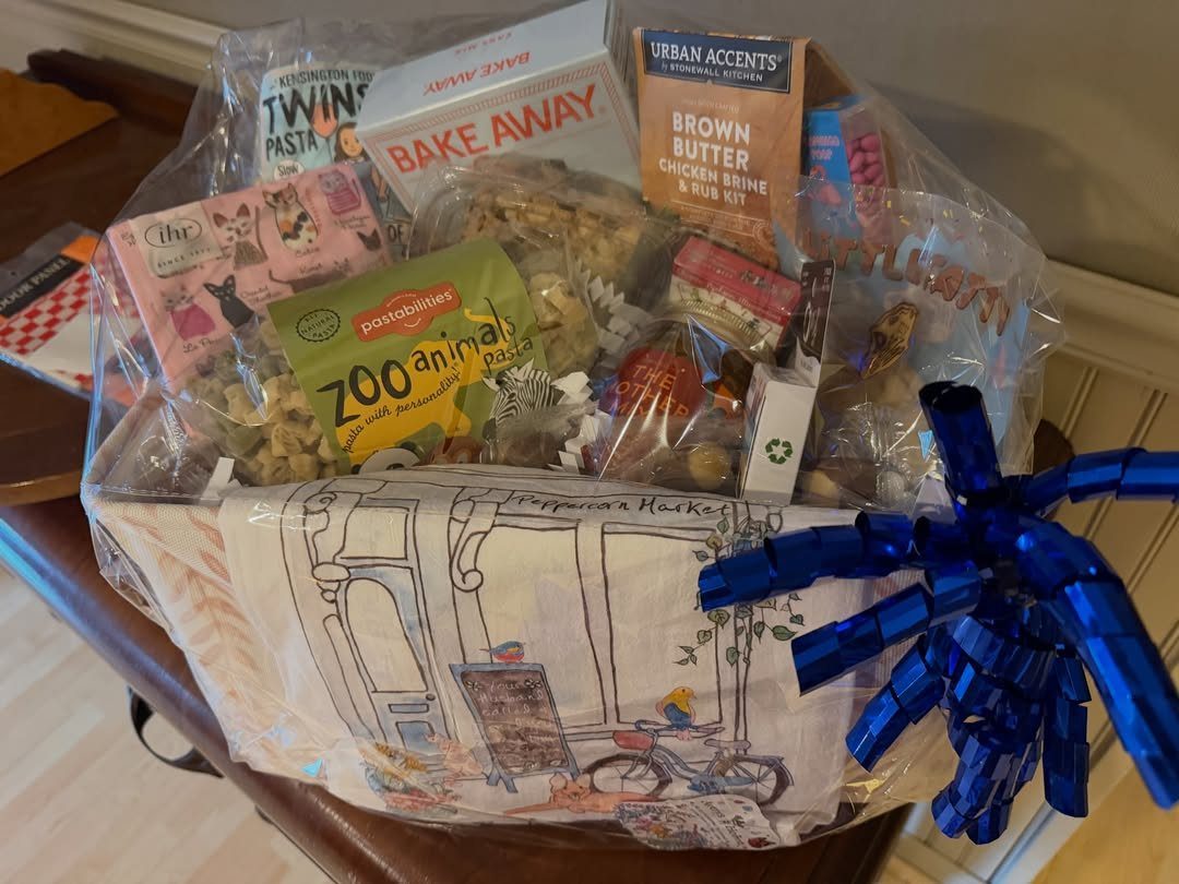 Gift basket with animal pasta and baking mixes wrapped in clear cellophane.